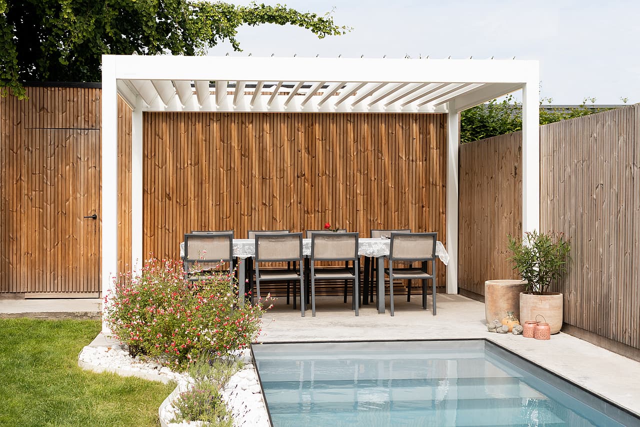 Weißes Brustor-Lamellendach über einer Poolterrasse
